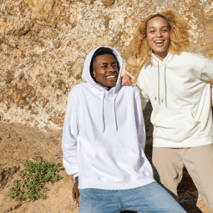 Two people smiling in casual hoodies outdoors.
