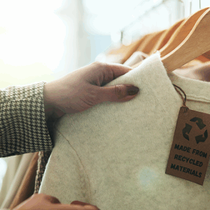 Hand holding eco friendly clothing with tag.