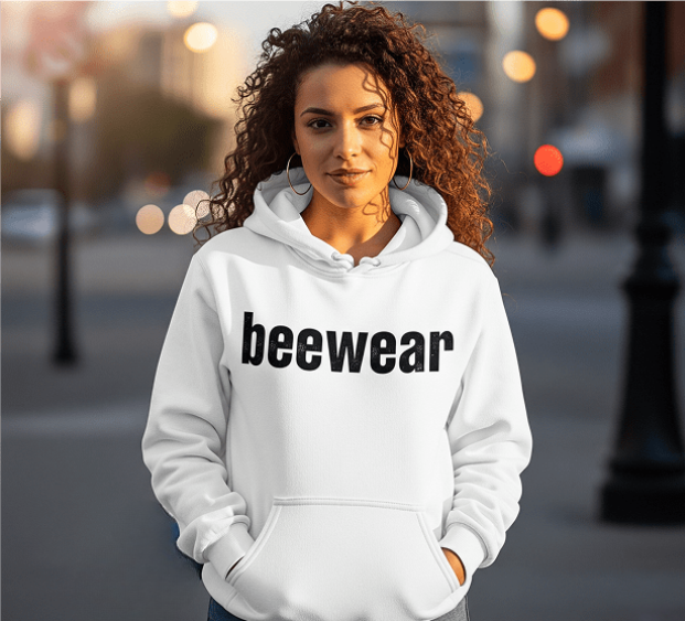 Woman wearing a white hoodie with beewear printed on it.